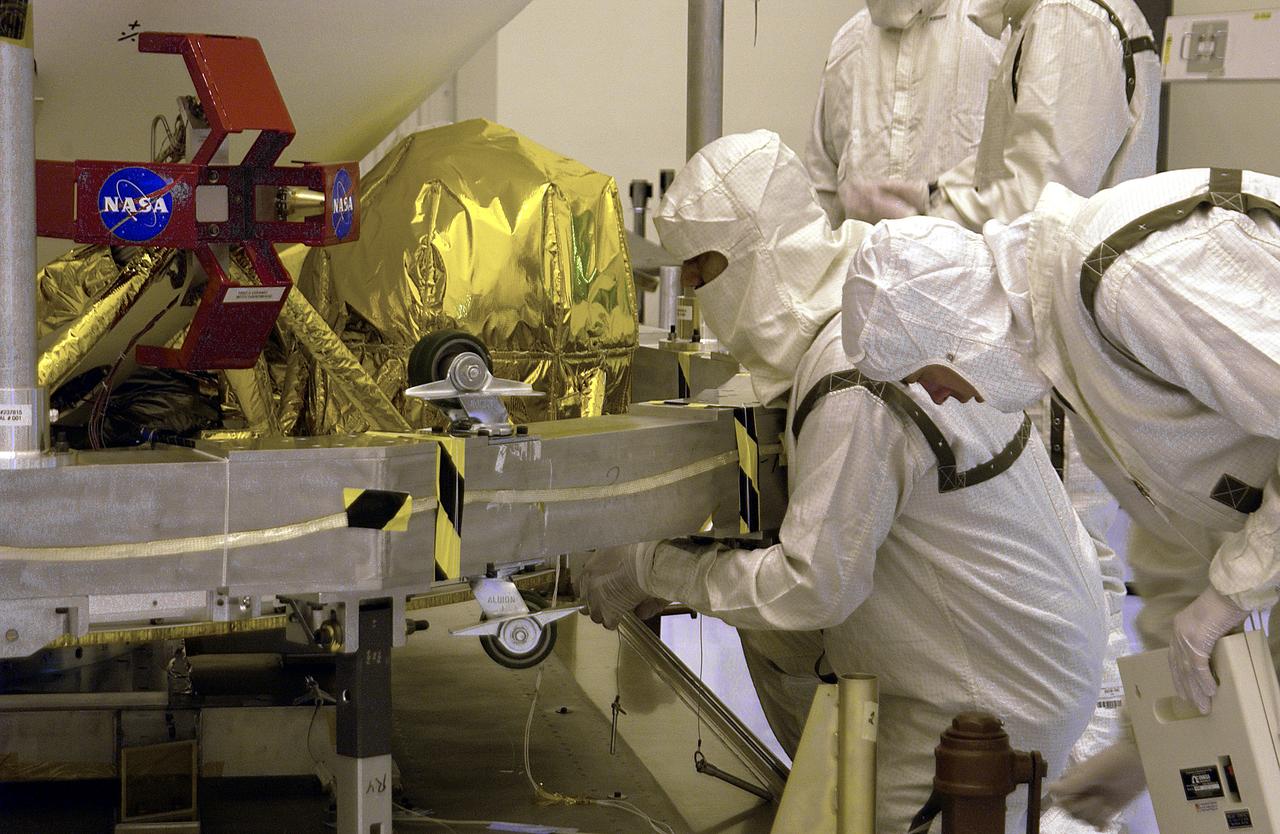 In the Payload Hazardous Servicing Facility, workers prepare the Mars Exploration Rover (MER) aeroshell for transfer to a rotation stand. Set to launch in 2003, the MER Mission will consist of two identical rovers designed to cover roughly 110 yards (100 meters) each Martian day. Each rover will carry five scientific instruments that will allow it to search for evidence of liquid water that may have been present in the planet's past. The rovers will be identical to each other, but will land at different regions of Mars. The first rover has a launch window opening May 30, and the second rover a window opening June 25, 2003.