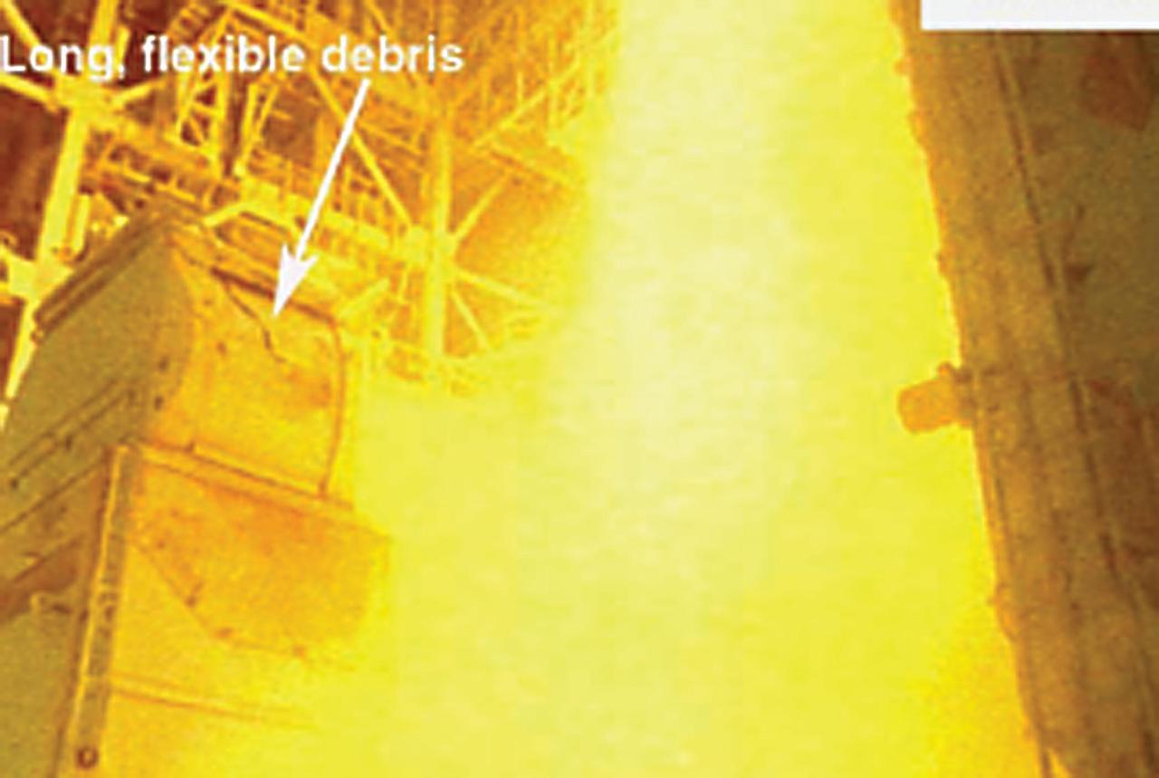 KENNEDY SPACE CENTER, FLA. - At the launch of Space Shuttle Columbia on mission STS-107, long, flexible debris comes out of the liquid helium 2 Tail Service Mast after the door closes.   Columbia and crew were lost in a tragic accident over Texas as they made their approach to landing at KSC.