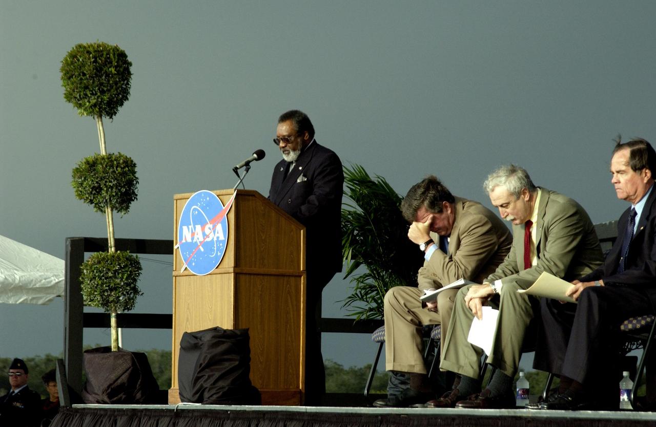 KENNEDY SPACE CENTER, FLA. -  A Columbia Crew Memorial Service is held at the Shuttle Landing Facility for KSC employees and invited guests. NASA Associate Deputy Administrator for Institutions and Asset Management James L. Jennings is at the podium. The Columbia and her crew of seven were lost on Feb. 1, 2003, over East Texas as they returned to Earth after a 16-day research mission.  Taking part in the service were NASA Administrator Sean O’Keefe, former KSC Director Robert Crippen, astronaut Jim Halsell, several employees, area clergymen, and members of Patrick Air Force Base.  The service concluded with a “Missing Man Formation Fly Over” by NASA T-38 jet aircraft.