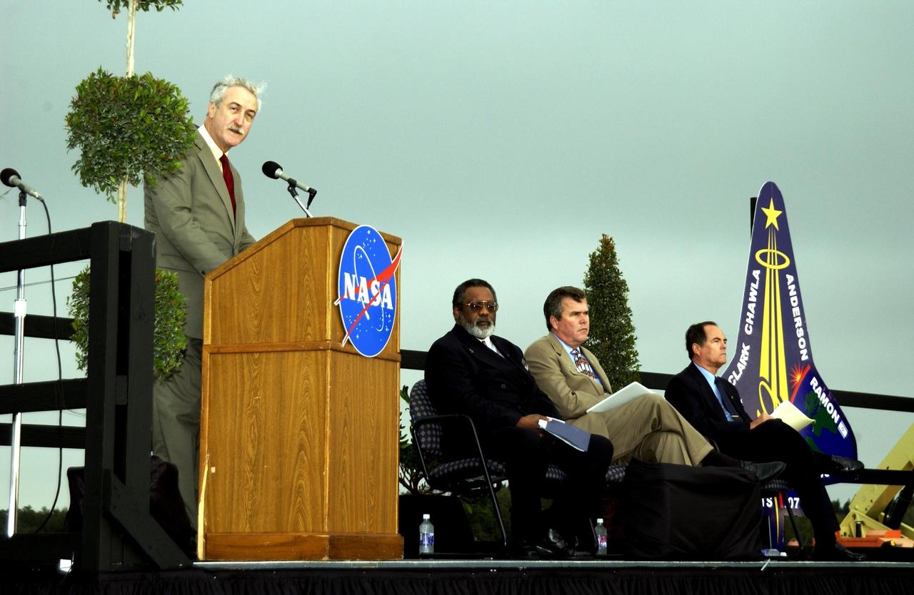 KENNEDY SPACE CENTER, FLA. -  A Columbia Crew Memorial Service is held at the Shuttle Landing Facility for KSC employees and invited guests. NASA Administrator Sean O'Keefe is at the podium. Seated to his right are NASA Associate Deputy Administrator for Institutions and Asset Management James L. Jennings, Florida Gov. Jeb Bush, and Columbia's first pilot and former KSC Director Robert Crippen. The Columbia and her crew of seven were lost on Feb. 1, 2003, over East Texas as they returned to Earth after a 16-day research mission.  Taking part in the service were NASA Administrator Sean O’Keefe, former KSC Director Robert Crippen, astronaut Jim Halsell, several employees, area clergymen, and members of Patrick Air Force Base.  The service concluded with a “Missing Man Formation Fly Over” by NASA T-38 jet aircraft.