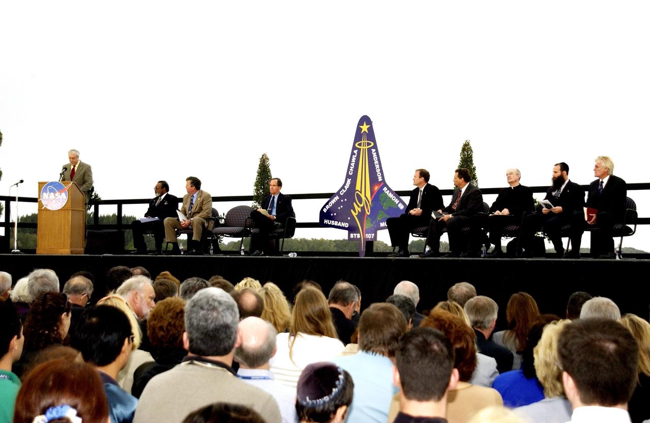 KENNEDY SPACE CENTER, FLA. -  A Columbia Crew Memorial Service is held at the Shuttle Landing Facility for KSC employees and invited guests. NASA Administrator Sean O'Keefe is at the podium. Seated to his right are NASA Associate Deputy Administrator for Institutions and Asset Management James L. Jennings, Florida Gov. Jeb Bush, and Columbia's first pilot and former KSC Director Robert Crippen. The Columbia and her crew of seven were lost on Feb. 1, 2003, over East Texas as they returned to Earth after a 16-day research mission.  Taking part in the service were NASA Administrator Sean O’Keefe, former KSC Director Robert Crippen, astronaut Jim Halsell, several employees, area clergymen, and members of Patrick Air Force Base.  The service concluded with a “Missing Man Formation Fly Over” by NASA T-38 jet aircraft.
