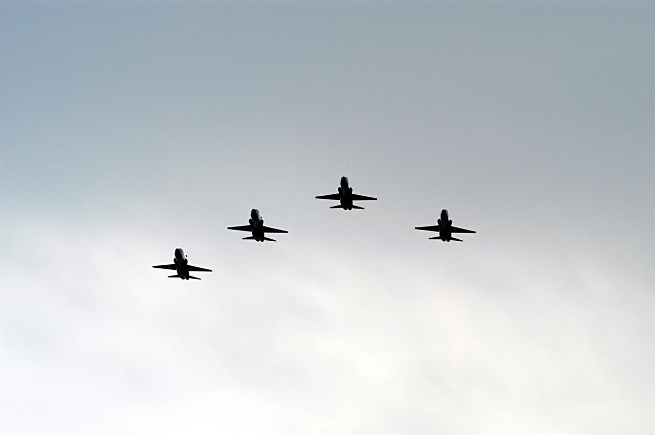 NASA T-38 jet aircraft are flying in a "Missing Man Formation" to conclude the memorial service for the crew of Columbia who were lost on Feb. 1, 2003, over East Texas as they returned to Earth after a 16-day research mission STS-107. The service was held at the Shuttle Landing Facility. Taking part in the service were NASA Administrator Sean O'Keefe, former KSC Director Robert Crippen, astronaut Jim Halsell, several employees, area clergymen, and members of Patrick Air Force Base. Crippen was the first to fly Columbia in 1981; Halsell first flew Columbia in 1994 and again in 1997. 