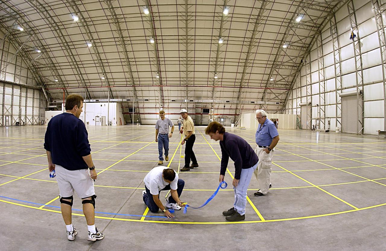 KENNEDY SPACE CENTER, FLA. - Workers inside the RLV Hangar at KSC help place grid marks on the floor.  The hangar is being readied to receive the parts of Columbia recovered after the tragic accident that also claimed the seven lives of the crew.  The grid marks will help with reconstruction of Columbia to the extent possible and final disposition.