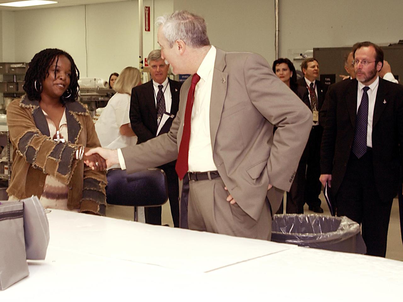 KENNEDY SPACE CENTER, FLA. --  NASA Administrator Sean O'Keefe (center) greets Brenda Blackmon, a worker in the Thermal Protection System Facility.  O'Keefe is visiting the site to learn more about the TPS products and process in protecting orbiters from the intense heat of launch and re-entry.  TPS tiles have been discussed in the investigation into the Columbia tragedy that destroyed the orbiter and claimed the lives of seven astronauts.