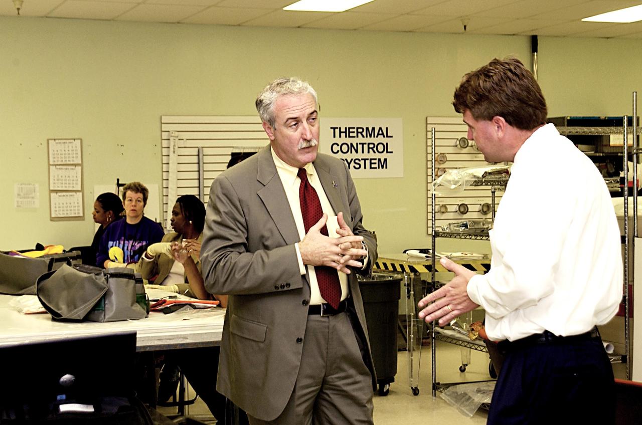 KENNEDY SPACE CENTER, FLA. -- In the Thermal Protection System Facility, NASA Administrator Sean O'Keefe (left) talks to Martin Wilson, project manager. O'Keefe is visiting the site to learn more about the TPS products and process in protecting orbiters from the intense heat of launch and re-entry.  TPS tiles have been discussed in the investigation into the Columbia tragedy that destroyed the orbiter and claimed the lives of seven astronauts.