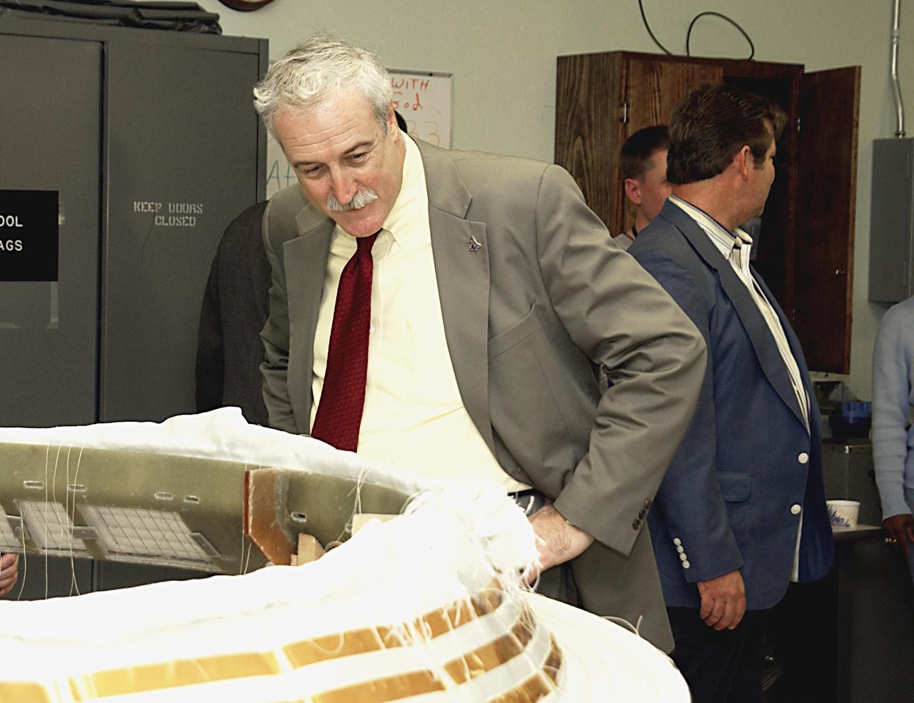 KENNEDY SPACE CENTER, FLA. -- In the Thermal Protection System Facility, NASA Administrator Sean O'Keefe looks at a Dome Heat Shield blanket that is used for Shuttle engines. O'Keefe is visiting the site to learn more about the TPS products and process in protecting orbiters from the intense heat of launch and re-entry.  TPS tiles have been discussed in the investigation into the Columbia tragedy that destroyed the orbiter and claimed the lives of seven astronauts.