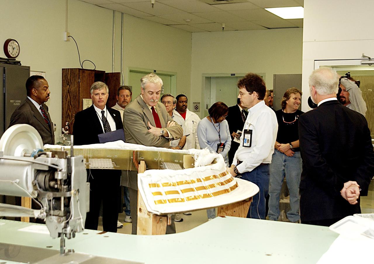 KENNEDY SPACE CENTER, FLA. -- In the Thermal Protection System Facility, NASA Administrator Sean O'Keefe (center) looks at a Dome Heat Shield blanket that is used for Shuttle engines.  From left is Glen Mahone, acting director for NASA Public Affairs, Jim Kennedy, deputy director of Kennedy Space Center, O'Keefe, Lee Zook, project leader, and Chuck Fontana, associate program manager, Integrated Logistics. O'Keefe is visiting the site to learn more about the TPS products and process in protecting orbiters from the intense heat of launch and re-entry.  TPS tiles have been discussed in the investigation into the Columbia tragedy that destroyed the orbiter and claimed the lives of seven astronauts.
