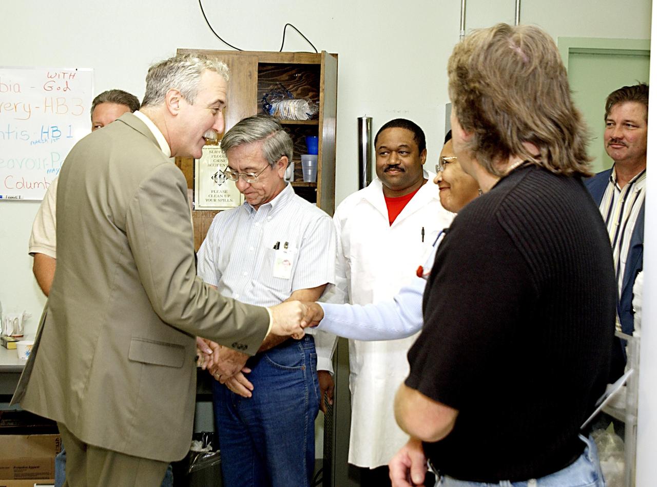 KENNEDY SPACE CENTER, FLA. -- In the Thermal Protection System Facility, NASA Administrator Sean O'Keefe (left) meets workers. O'Keefe is visiting the site to learn more about the TPS products and process in protecting orbiters from the intense heat of launch and re-entry.  TPS tiles have been discussed in the investigation into the Columbia tragedy that destroyed the orbiter and claimed the lives of seven astronauts.