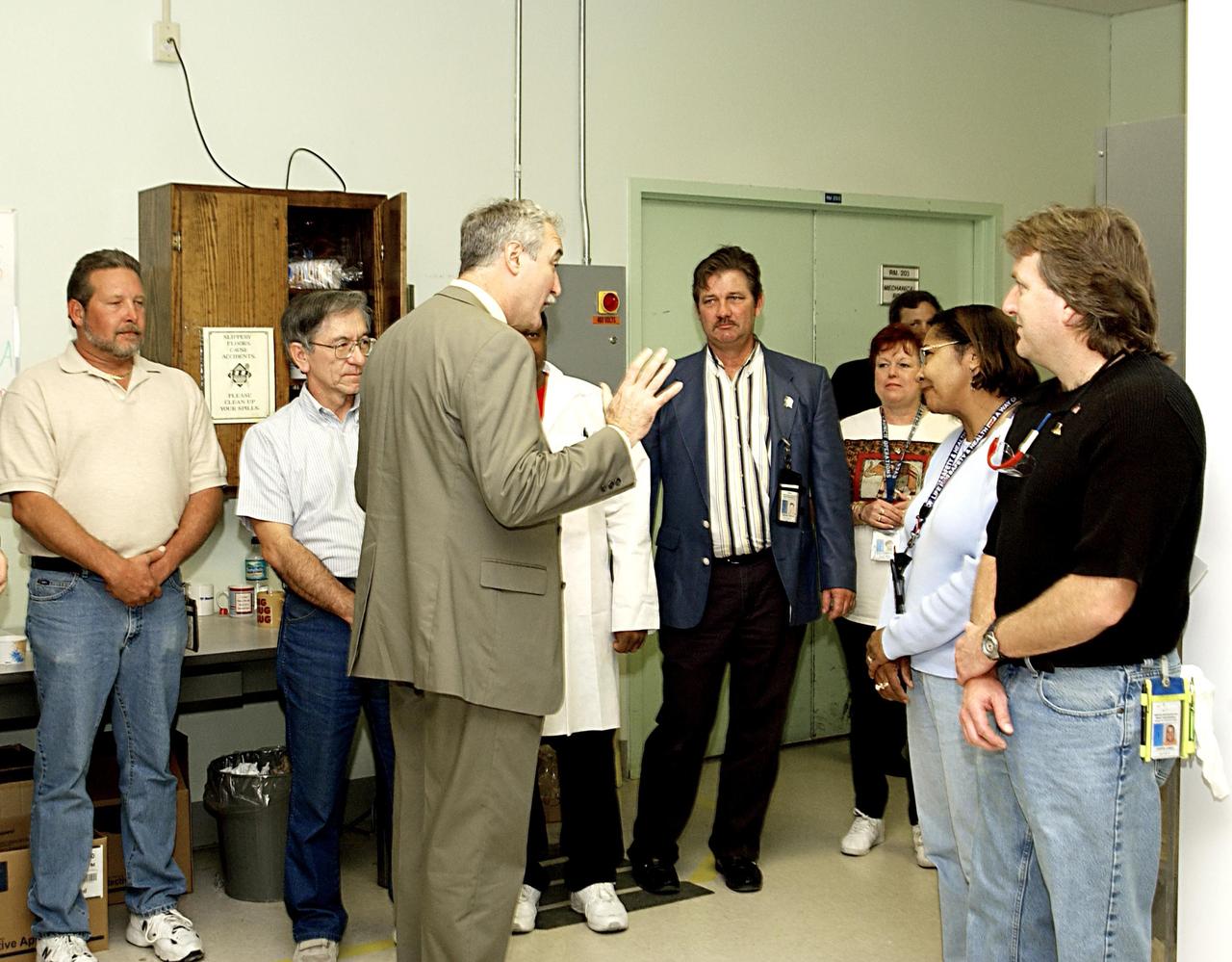 KENNEDY SPACE CENTER, FLA. -- NASA Administrator Sean O'Keefe (third from left) talks to workers in the Thermal Protection System Facility. O'Keefe is visiting the site to learn more about the TPS products and process in protecting orbiters from the intense heat of launch and re-entry.  TPS tiles have been discussed in the investigation into the Columbia tragedy that destroyed the orbiter and claimed the lives of seven astronauts.