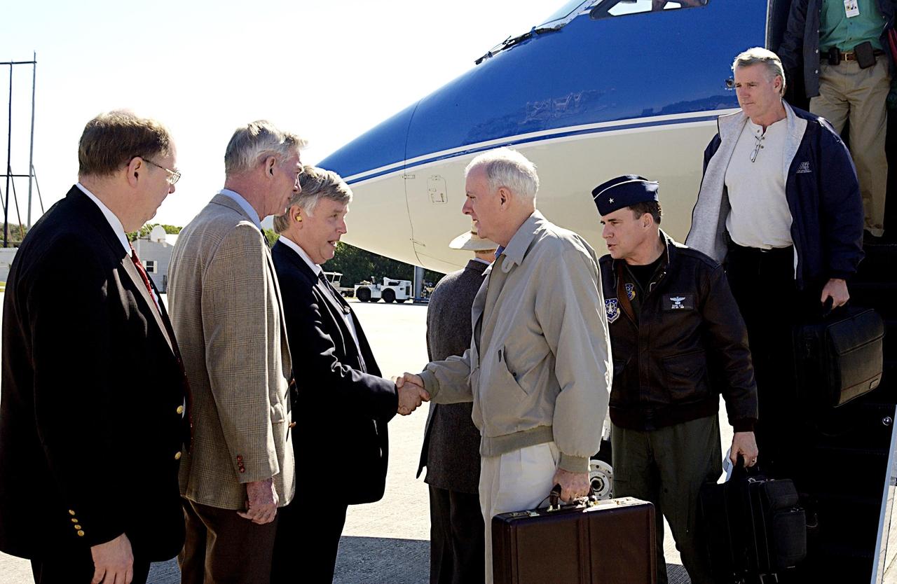 KENNEDY SPACE CENTER, FLA. -- Retired Navy Admiral Harold W. Gehman Jr. (center, with briefcase), chairman of the Columbia Accident Board, is greeted by KSC Deputy Director James Kennedy after Gehman's arrival at the KSC Shuttle Landing Facility.   At far left is Wayne Hale, manager of Space Shuttle Program Launch Integration.  Gehman and other members of the board, disembarking behind him, are visiting sites at KSC to become familiar with the Shuttle launch process. The independent board is charged with determining what caused the destruction of the Space Shuttle Columbia and the loss of its seven-member crew on Feb. 1 during reentry.
