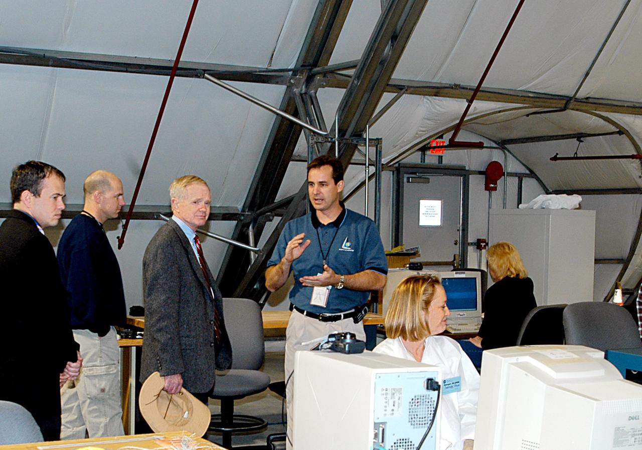 KENNEDY SPACE CENTER, FLA. - KSC Director Roy D. Bridges (third from left) inspects Columbia debris arriving at KSC from the collection point at Barksdale Air Force Base, Shreveport, La.  The debris is being collected at the RLV Hangar near the Shuttle Landing Facility.  Workers there will attempt to reconstruct the orbiter as part of the ongoing investigation of the accident that destroyed the Columbia and claimed the lives of seven astronauts as they returned to Earth after a 16-day research mission, STS-107.