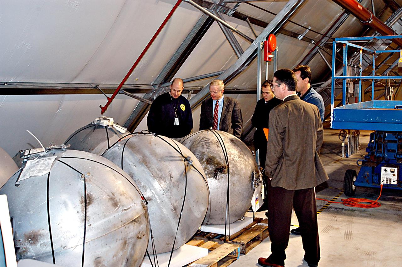 KENNEDY SPACE CENTER, FLA. - KSC Director Roy D. Bridges (second from left) inspects Columbia debris arriving at KSC from the collection point at Barksdale Air Force Base, Shreveport, La.  The debris is being collected at the RLV Hangar near the Shuttle Landing Facility.  Workers there will attempt to reconstruct the orbiter as part of the ongoing investigation of the accident that destroyed the Columbia and claimed the lives of seven astronauts as they returned to Earth after a 16-day research mission, STS-107.