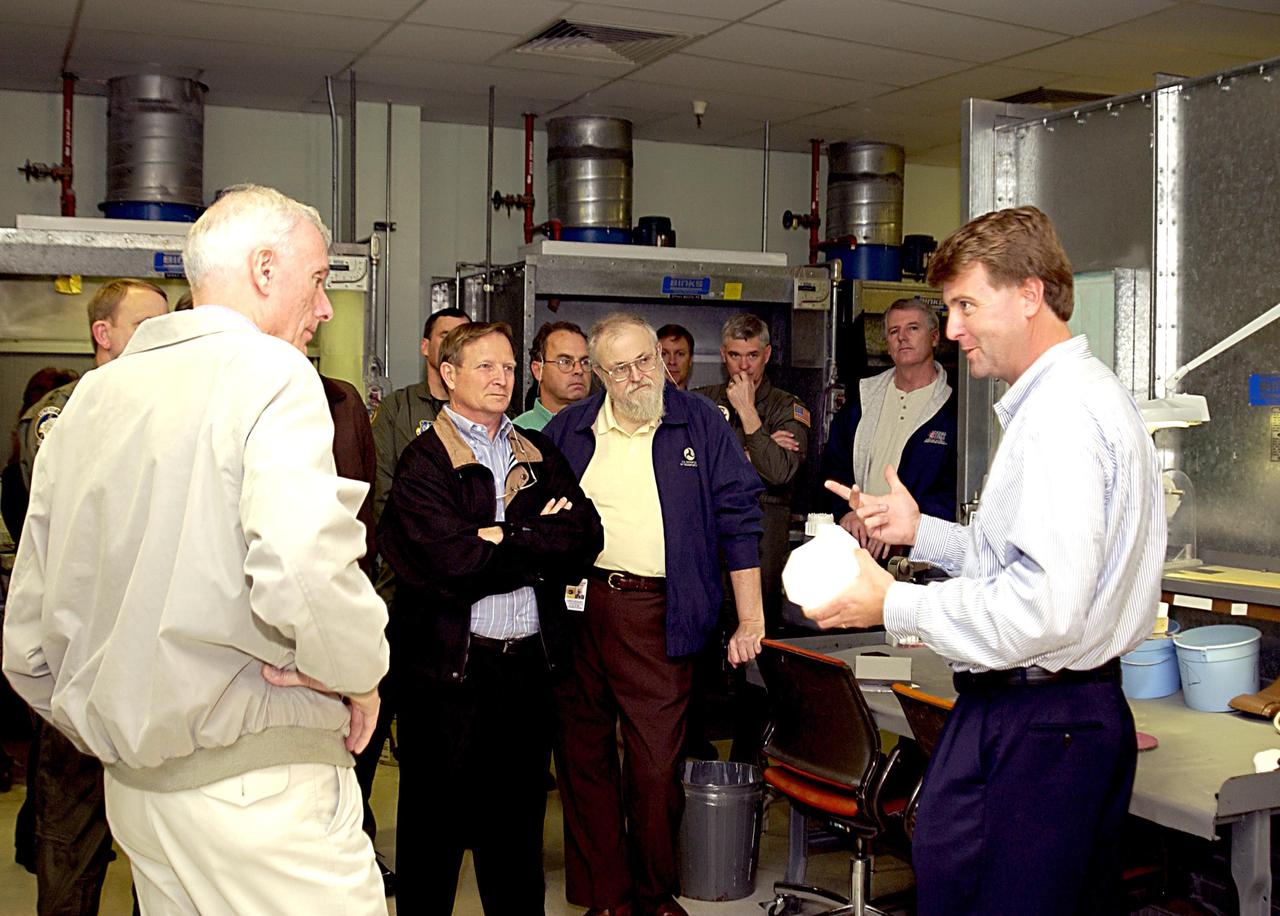 KENNEDY SPACE CENTER, FLA. - Retired Navy Admiral Harold W. Gehman Jr. (left), chairman of the Columbia Accident Investigation Board, visits the Thermal Protection System shop and is briefed by Martin Wilson (right), the shop manager. Gehman and other members of the board are visiting sites at KSC to become familiar with the Shuttle launch process. The independent board is charged with determining what caused the destruction of the Space Shuttle Columbia and the loss of its seven-member crew on Feb. 1 during reentry.