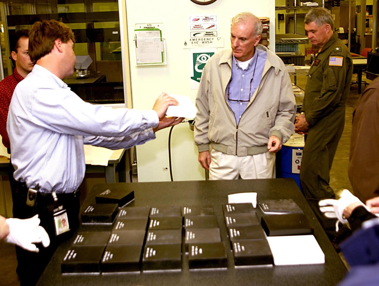KENNEDY SPACE CENTER, FLA. - Retired Navy Admiral Harold W. Gehman Jr. (second from right), chairman of the Columbia Accident Investigation Board, visits the Thermal Protection System shop and is briefed by Martin Wilson (left), the shop manager. Gehman and other members of the board are visiting sites at KSC to become familiar with the Shuttle launch process. The independent board is charged with determining what caused the destruction of the Space Shuttle Columbia and the loss of its seven-member crew on Feb. 1 during reentry.