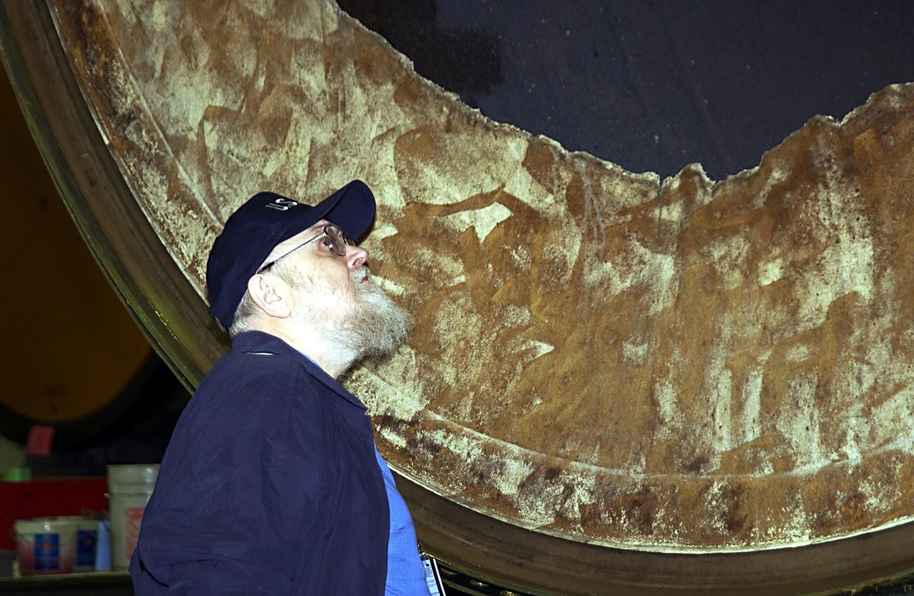 KENNEDY SPACE CENTER, FLA. --  Dr. James Hallock looks over a portion of a solid rocket booster in the Hangar AF (the SRB Disassembly Facility).  He is a member of the Columbia Accident Investigation Board that is visiting sites at KSC to become familiar with the Shuttle launch process and elements. The independent board is charged with determining what caused the destruction of the Space Shuttle Columbia and the loss of its seven-member crew on Feb. 1 during reentry.