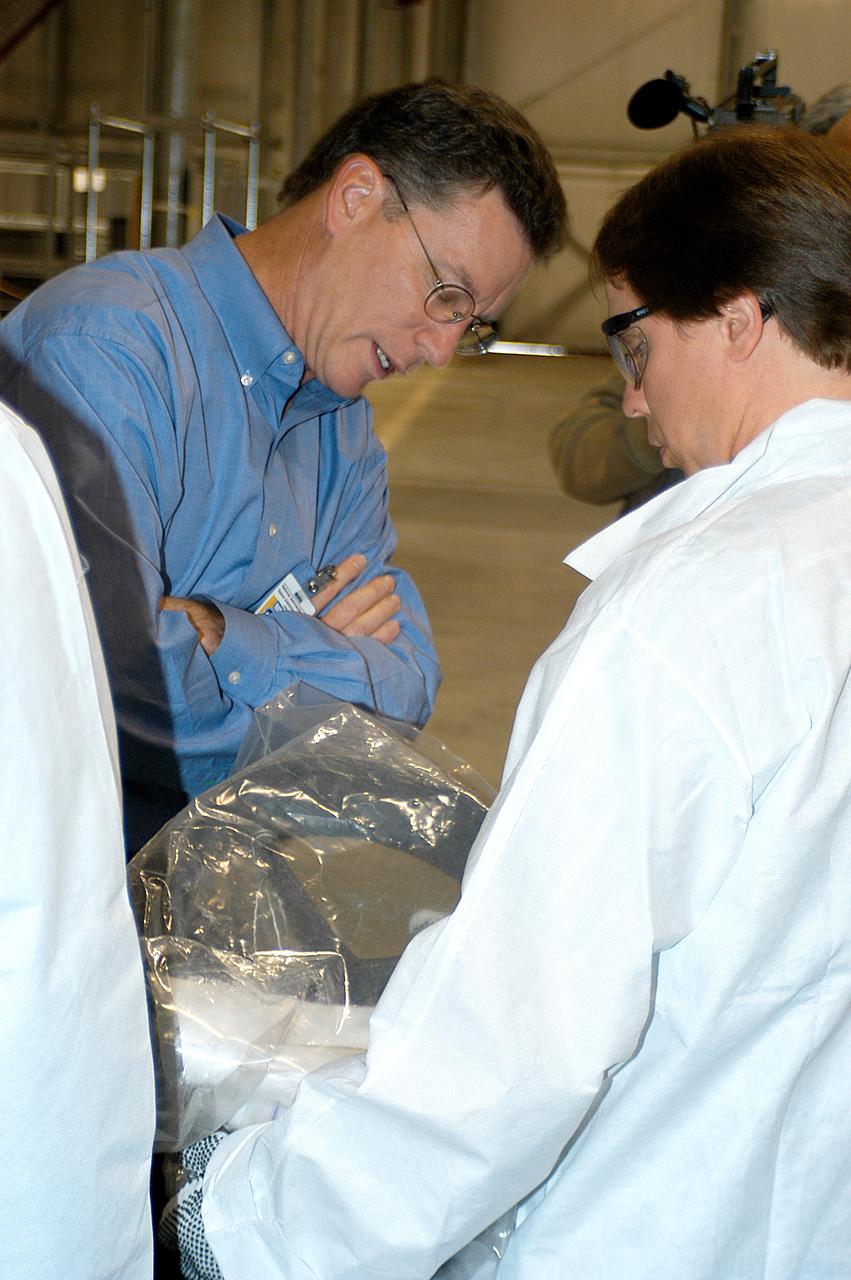 Astronauts Lee Archambault and Joan Higginbotham look at a piece of Columbia debris placed on the grid in the RLV Hangar. The debris was shipped from Barksdale Air Force Base, Shreveport, La. As part of the ongoing investigation into the tragic accident, workers will attempt to reconstruct the orbiter inside the RLV. 