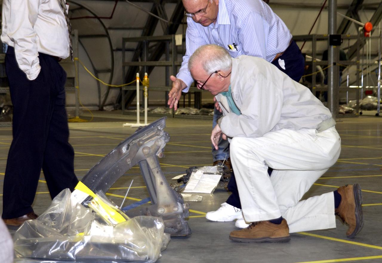 KENNEDY SPACE CENTER, FLA. --  Members of the Columbia Accident Investigation Board examine a piece of Columbia debris in the RLV Hangar. The debris was shipped from the collection point at Barksdale Air Force Base, Shreveport, La.  As part of the ongoing investigation into the tragic accident that claimed Columbia and her crew of seven, workers will attempt to reconstruct the orbiter inside the RLV.