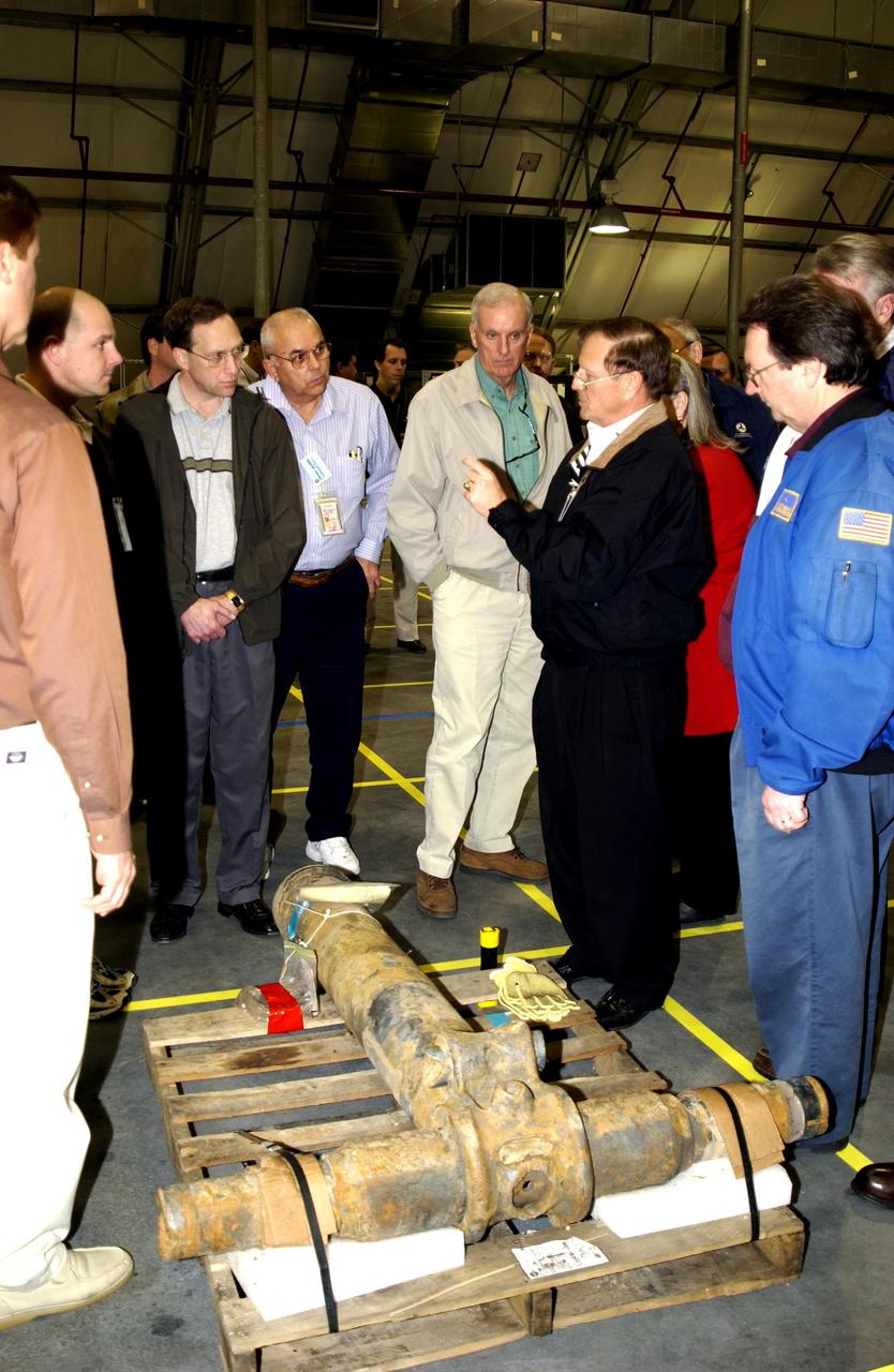 KENNEDY SPACE CENTER, FLA. --  Members of the Columbia Accident Investigation Board examine pieces of Columbia debris in the RLV Hangar. The debris was shipped from the collection point at Barksdale Air Force Base, Shreveport, La.  As part of the ongoing investigation into the tragic accident that claimed Columbia and her crew of seven, workers will attempt to reconstruct the orbiter inside the RLV.