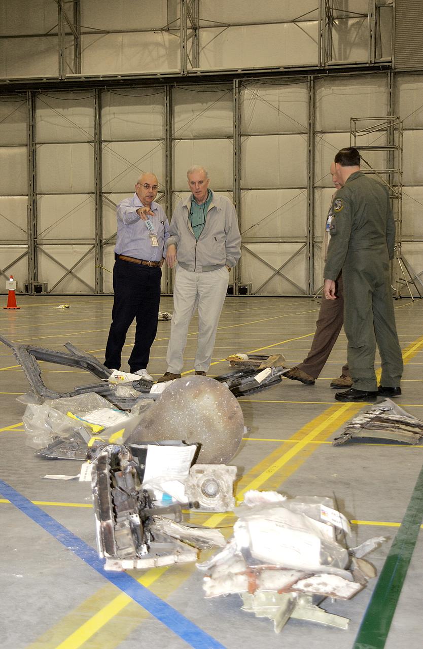Members of the Columbia Accident Investigation Board examine pieces of Columbia debris in the RLV Hangar. The debris was shipped from the collection point at Barksdale Air Force Base, Shreveport, La. As part of the ongoing investigation into the tragic accident that claimed Columbia and her crew of seven, workers will attempt to reconstruct the orbiter inside the RLV. 