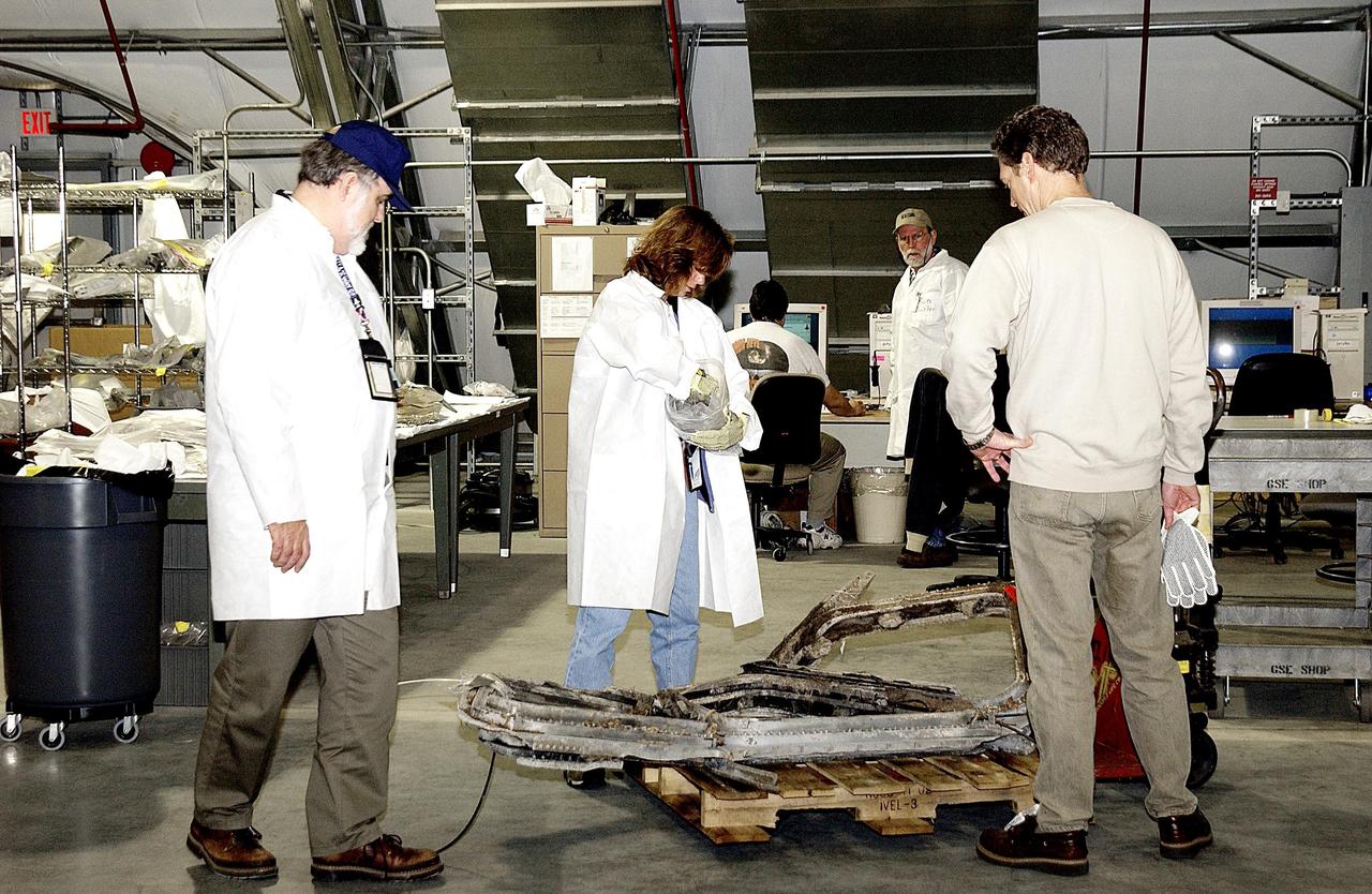 KENNEDY SPACE CENTER, FLA. -- Columbia Reconstruction Project Team members catalog debris from the Space Shuttle Columbia positioned in the RLV Hangar. The debris is being shipped to KSC from the collection point at Barksdale Air Force Base, Shreveport, La. As part of the ongoing investigation into the tragic accident that claimed Columbia and her crew of seven, workers will attempt to reconstruct the orbiter inside the hangar.