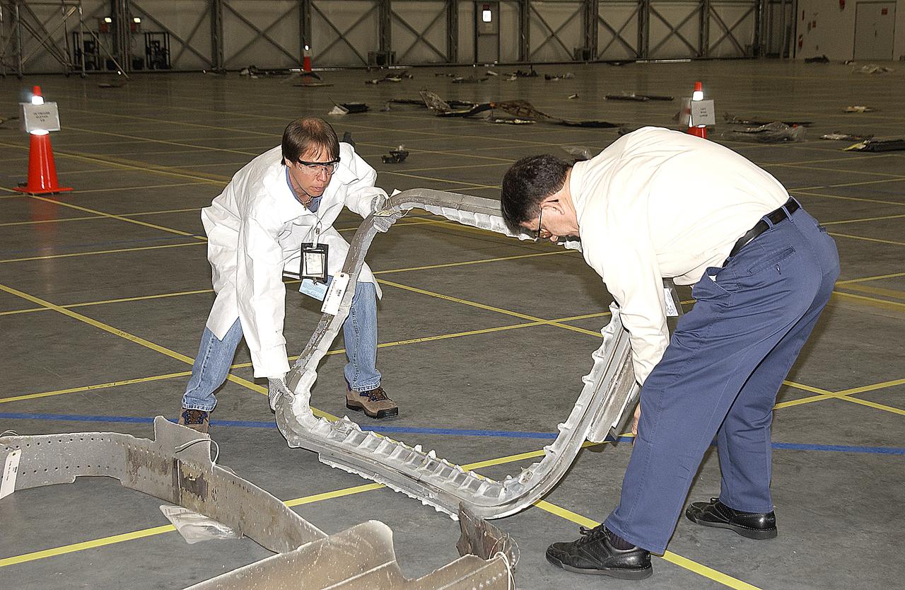 Columbia Reconstruction Project Team members move a piece of debris from the Space Shuttle Columbia into a specified sector of the RLV Hangar. The debris is being shipped to KSC from the collection point at Barksdale Air Force Base, Shreveport, La. As part of the ongoing investigation into the tragic accident that claimed Columbia and her crew of seven, workers will attempt to reconstruct the orbiter inside the hangar.