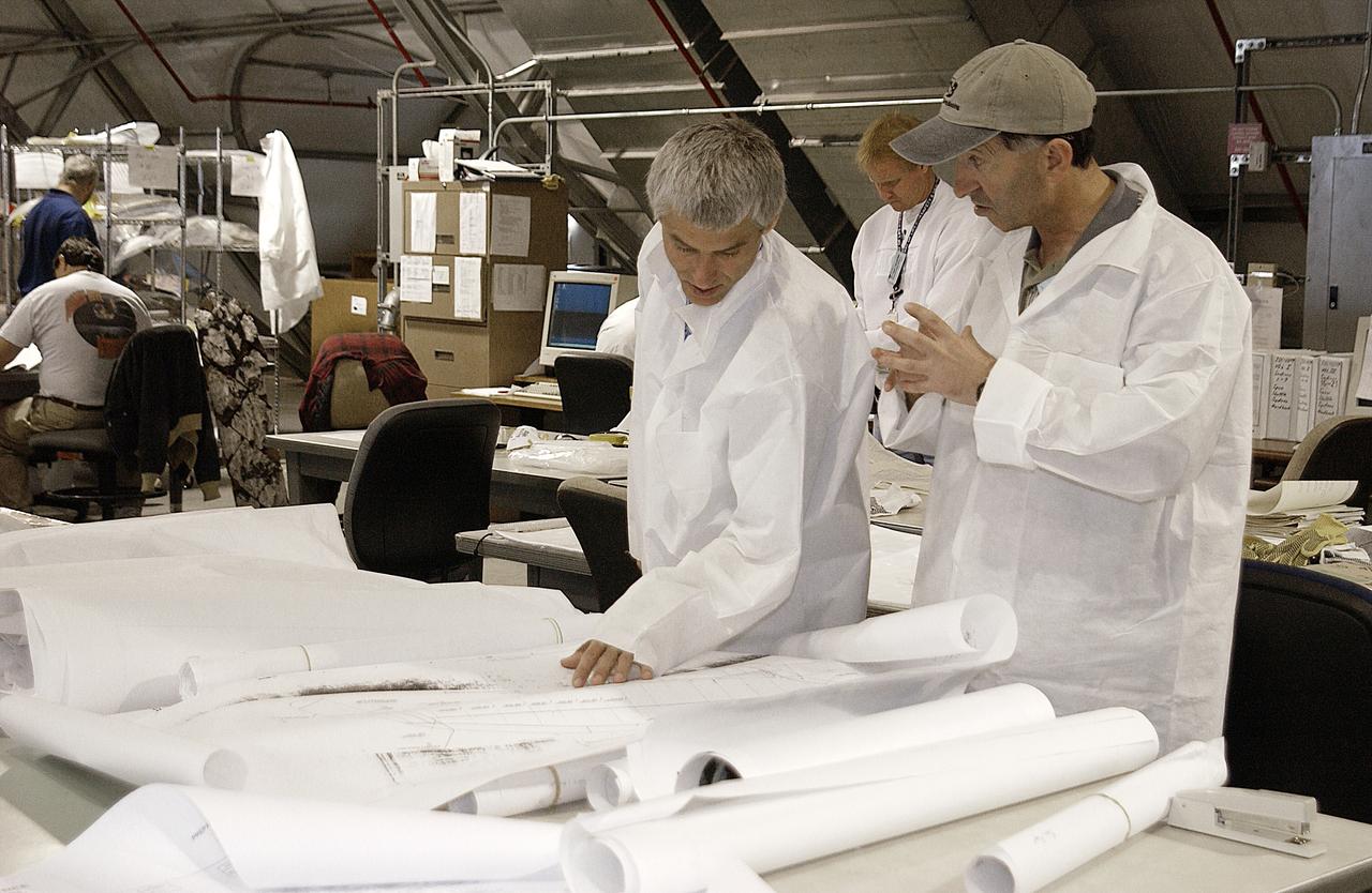 Columbia Reconstruction Project Team members study diagrams to aid in the placement of debris from the Space Shuttle Columbia in the RLV Hangar. The debris is being shipped to KSC from the collection point at Barksdale Air Force Base, Shreveport, La. As part of the ongoing investigation into the tragic accident that claimed Columbia and her crew of seven, workers will attempt to reconstruct the orbiter inside the hangar.