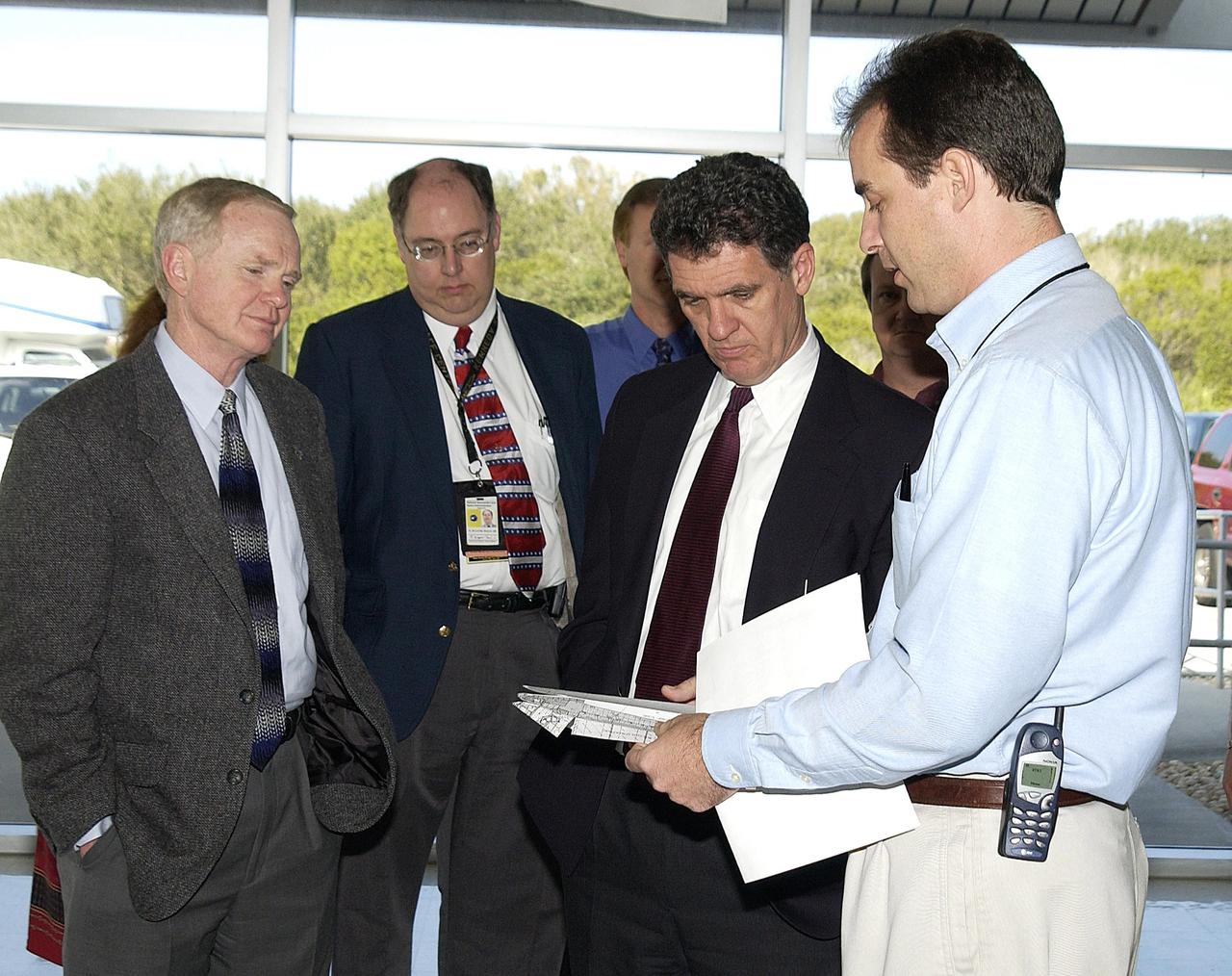 KENNEDY SPACE CENTER, FLA. --  Center Director Roy Bridges (left) accompanies Congressman Dave Weldon (second from right) on his visit to the RLV Hangar where pieces of Columbia debris are being examined and stored. At right is Steve Altemus, Space Shuttle test director.  Workers will attempt to reconstruct the orbiter as part of the ongoing investigation of the accident that destroyed the Columbia and claimed the lives of seven astronauts as they returned to Earth after a 16-day research mission, STS-107.