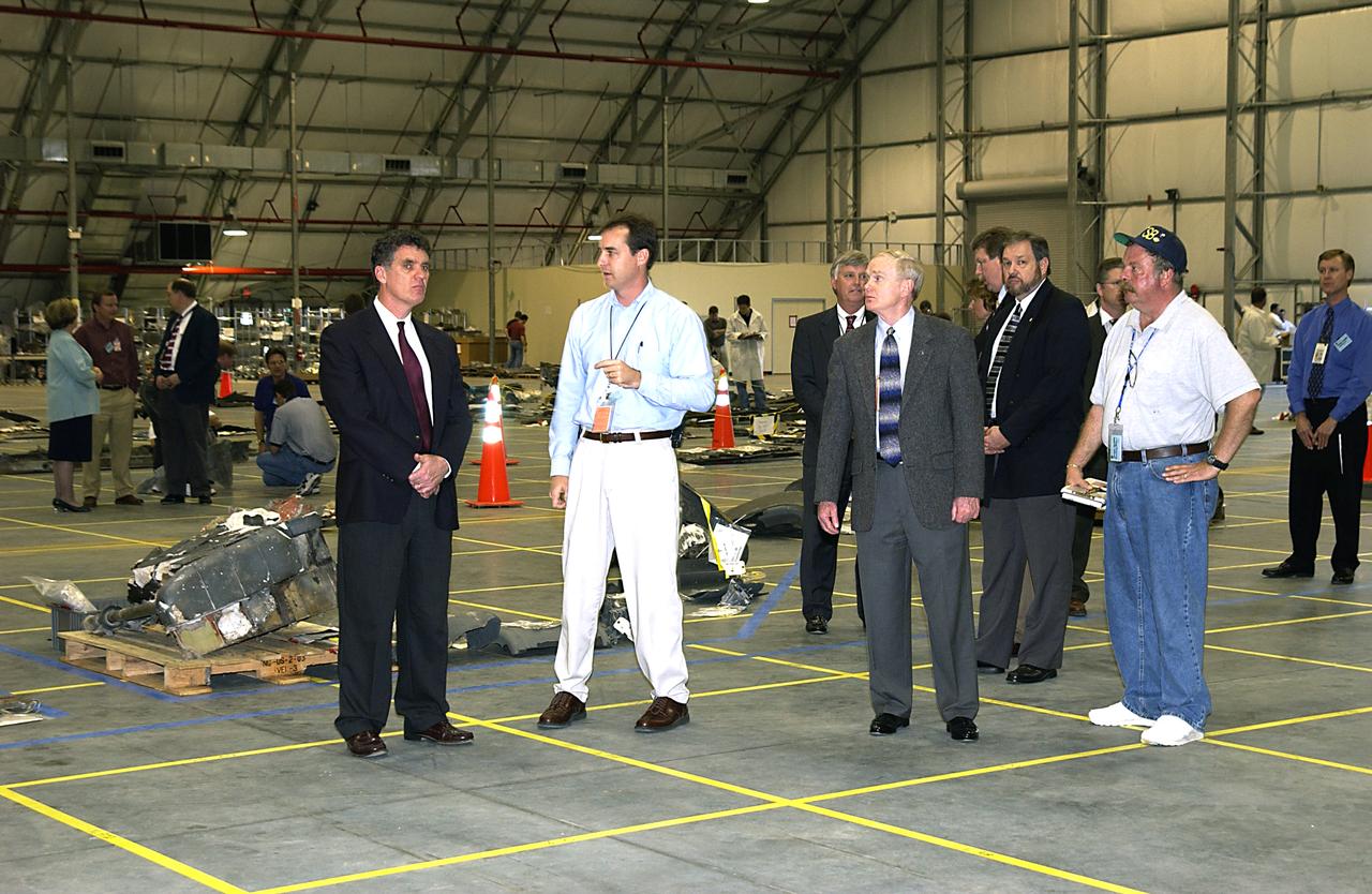 In the RLV Hangar, Congressman Dave Weldon (left) listens to Steve Altemus, Space Shuttle test director. Weldon is visiting the site where pieces of Columbia debris are being examined and stored. Third from left is Center Director Roy Bridges. Workers will attempt to reconstruct the orbiter as part of the ongoing investigation of the accident that destroyed the Columbia and claimed the lives of seven astronauts as they returned to Earth after a 16-day research mission, STS-107. 
