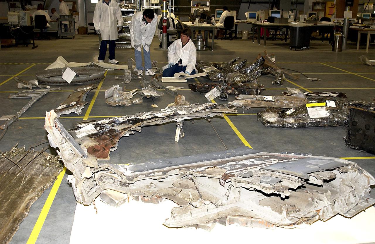 KENNEDY SPACE CENTER, FLA. -- Columbia Reconstruction Project Team members catalog pieces of debris from the Space Shuttle Columbia in the RLV Hangar. The debris arrived at KSC today from the collection point at Barksdale Air Force Base, Shreveport, La. As part of the ongoing investigation into the tragic accident that claimed Columbia and her crew of seven, workers will attempt to reconstruct the orbiter inside the hangar.