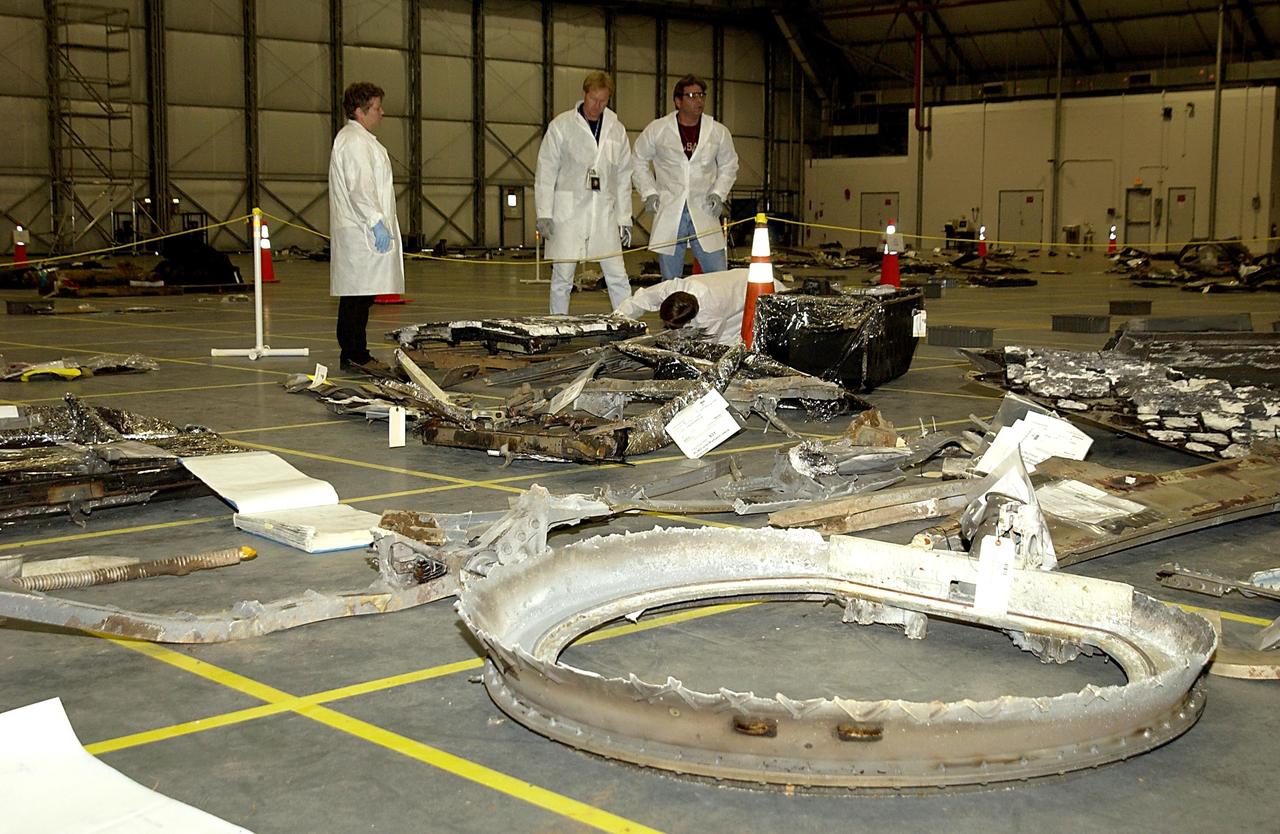 KENNEDY SPACE CENTER, FLA. -- Columbia Reconstruction Project Team members survey pieces of debris from the Space Shuttle Columbia in the RLV Hangar. The debris arrived at KSC today from the collection point at Barksdale Air Force Base, Shreveport, La. As part of the ongoing investigation into the tragic accident that claimed Columbia and her crew of seven, workers will attempt to reconstruct the orbiter inside the hangar.