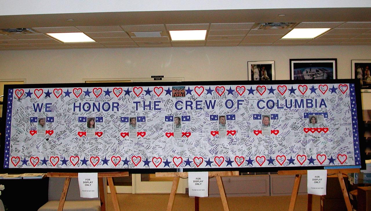 KENNEDY SPACE CENTER, FLA. --  A large poster in tribute to the Columbia astronauts who were lost in the Shuttle's explosion Feb. 1, is on display in the NASA News Center at KSC.   The poster was signed by young women attending the Sally Ride Science Festival at the University of Central Florida, Orlando, Fla.  The Sally Ride event promotes science, math and technology as future career paths for girls. Former astronaut Sally Ride addressed the girls at the festival, while breakout sessions afforded closer interaction between Ride and festival attendees.