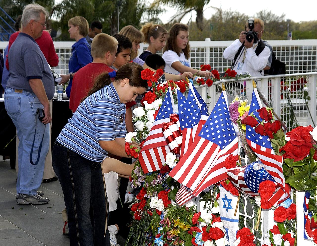 KENNEDY SPACE CENTER, FLA. - Students from Columbia Elementary School in Palm Bay, Fla., place flowers at the Astronaut Memorial to honor the fallen crew of Space Shuttle Columbia. The students visited the Center to learn about the past, present and future of space exploration.  They also listened to Kirstie McCool Chadwick, the sister of Columbia astronaut William "Willie" J. McCool, and saw the 3-D IMAX film "Space Station."
