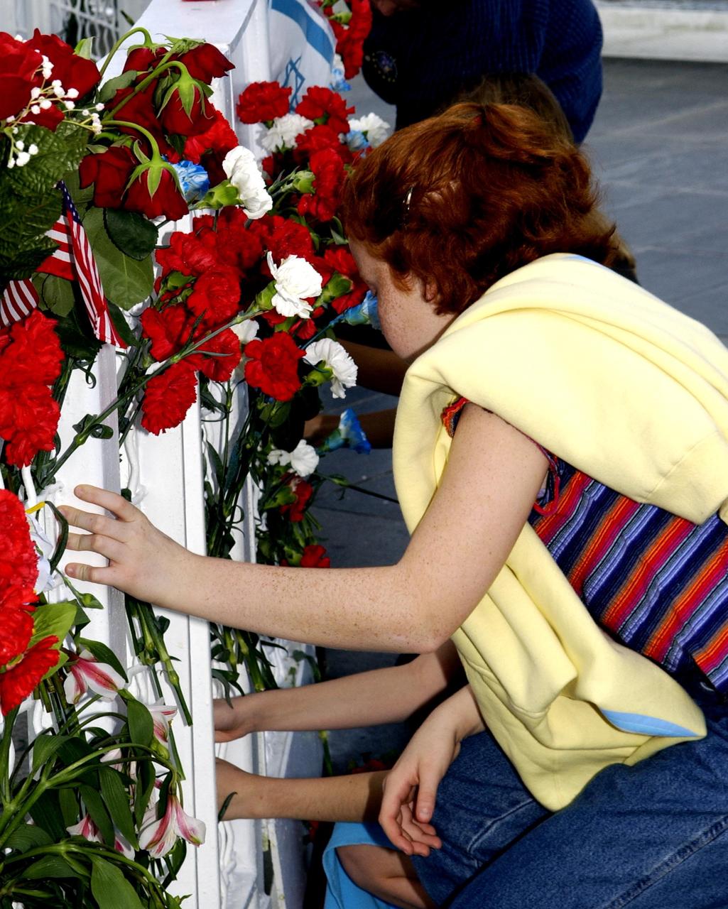 KENNEDY SPACE CENTER, FLA. - Students from Columbia Elementary School in Palm Bay, Fla., place flowers at the Astronaut Memorial to honor the fallen crew of Space Shuttle Columbia. The students visited the Center to learn about the past, present and future of space exploration.  They also listened to Kirstie McCool Chadwick, the sister of Columbia astronaut William "Willie" J. McCool, and saw the 3-D IMAX film "Space Station."