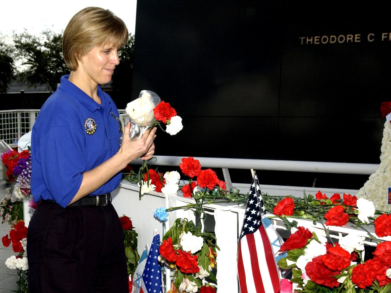 KENNEDY SPACE CENTER, FLA. -- Kirstie McCool Chadwick, the sister of Columbia astronaut William "Willie" J. McCool, places flowers at the Astronaut Memorial to honor the fallen crew of Space Shuttle Columbia.  She joined students from Columbia Elementary School in Palm Bay, Fla., who also paid tribute to the Columbia crew. The students visited the Center to learn about the past, present and future of space exploration.