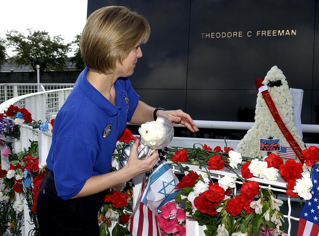 KENNEDY SPACE CENTER, FLA. -- Kirstie McCool Chadwick, the sister of Columbia astronaut William "Willie" J. McCool, places flowers at the Astronaut Memorial to honor the fallen crew of Space Shuttle Columbia.  She joined students from Columbia Elementary School in Palm Bay, Fla., who also paid tribute to the Columbia crew. The students visited the Center to learn about the past, present and future of space exploration.