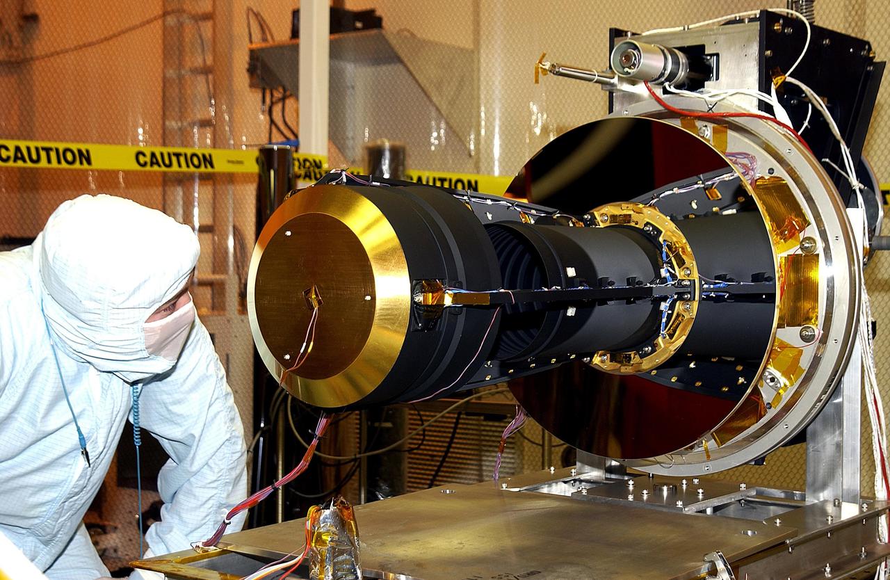 KENNEDY SPACE CENTER, FLA. -- In the Multi-Payload Processing Facility, a worker inspects the GALEX satellite after its rotation on a stand. The Galaxy Evolution Explorer (GALEX) is an orbiting space telescope that will observe galaxies in ultraviolet light across 10 billion years of cosmic history. Led by the California Institute of Technology, GALEX will conduct several first-of-a-kind sky surveys, including an extra-galactic (beyond our galaxy) ultraviolet all-sky survey. During its 29-month mission GALEX will produce the first comprehensive map of a Universe of galaxies under construction, bringing more understanding of how galaxies like the Milky Way were formed. GALEX is due to be launched from Cape Canaveral Air Force Station March 25 via a Pegasus rocket.