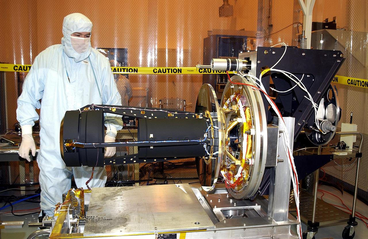 KENNEDY SPACE CENTER, FLA. -- In the Multi-Payload Processing Facility, a worker checks over the GALEX satellite on a rotation stand. The Galaxy Evolution Explorer (GALEX) is an orbiting space telescope that will observe galaxies in ultraviolet light across 10 billion years of cosmic history. Led by the California Institute of Technology, GALEX will conduct several first-of-a-kind sky surveys, including an extra-galactic (beyond our galaxy) ultraviolet all-sky survey. During its 29-month mission GALEX will produce the first comprehensive map of a Universe of galaxies under construction, bringing more understanding of how galaxies like the Milky Way were formed.  GALEX is due to be launched from Cape Canaveral Air Force Station March 25 via a Pegasus rocket.