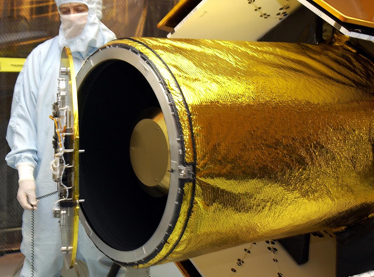 KENNEDY SPACE CENTER, FLA. -- In the Multi-Payload Processing Facility, workers check the deployment of the cover of the telescope on the GALEX satellite. The Galaxy Evolution Explorer (GALEX) is an orbiting space telescope that will observe galaxies in ultraviolet light across 10 billion years of cosmic history. Led by the California Institute of Technology, GALEX will conduct several first-of-a-kind sky surveys, including an extra-galactic (beyond our galaxy) ultraviolet all-sky survey. During its 29-month mission GALEX will produce the first comprehensive map of a Universe of galaxies under construction, bringing more understanding of how galaxies like the Milky Way were formed. GALEX is due to be launched from Cape Canaveral Air Force Station March 25 via a Pegasus rocket.
