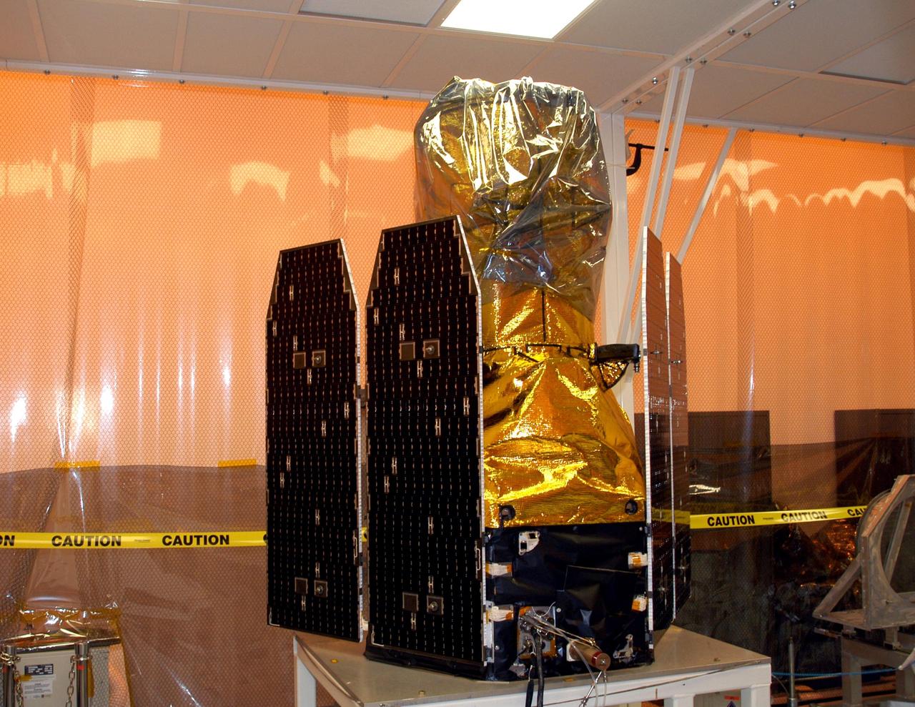 KENNEDY SPACE CENTER, FLA. - The Galaxy Evolution Explorer (GALEX) satellite is ready for deployment of its solar array panels during processing in the Multi-Payload Processing Facility. The GALEX is an orbiting space telescope that will observe galaxies in ultraviolet light across 10 billion years of cosmic history. Led by the California Institute of Technology, GALEX will conduct several first-of-a-kind sky surveys, including an extra-galactic (beyond our galaxy) ultraviolet all-sky survey. During its 29-month mission GALEX will produce the first comprehensive map of a Universe of galaxies under construction, bringing more understanding of how galaxies like the Milky Way were formed.  GALEX is due to be launched from Cape Canaveral Air Force Station March 25 via a Pegasus rocket.