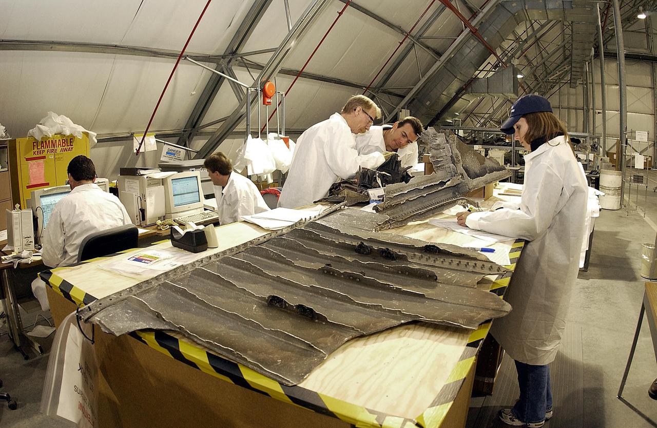KENNEDY SPACE CENTER, FLA. - Members of the Columbia Reconstruction Program Team record debris from Columbia after its arrival at the KSC RLV Hangar. Workers are attempting to reconstruct the orbiter inside the hangar as part of the ongoing investigation into the tragic accident that claimed Columbia and her crew of seven returning from mission STS-107.