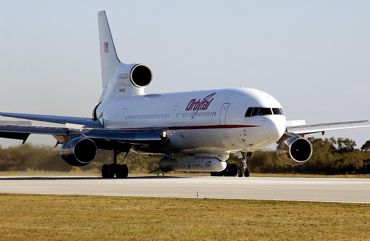 KENNEDY SPACE CENTER, FLA. --   The Orbital Sciences Corp.'s L-1011 aircraft arrives at the Skid Strip, Cape Canaveral Air Force Station, with the Pegasus rocket attached below.  The Pegasus will carry ito orbit the Galaxy Evolution Explorer (GALEX), an orbiting space telescope that will observe galaxies in ultraviolet light across 10 billion years of cosmic history. Led by the California Institute of Technology, GALEX will conduct several first-of-a-kind sky surveys, including an extra-galactic (beyond our galaxy) ultraviolet all-sky survey. During its 29-month mission, GALEX will produce the first comprehensive map of a Universe of galaxies under construction, bringing more understanding how galaxies like the Milky Way were formed.  GALEX is due to be launched from Cape Canaveral Air Force Station March 25.