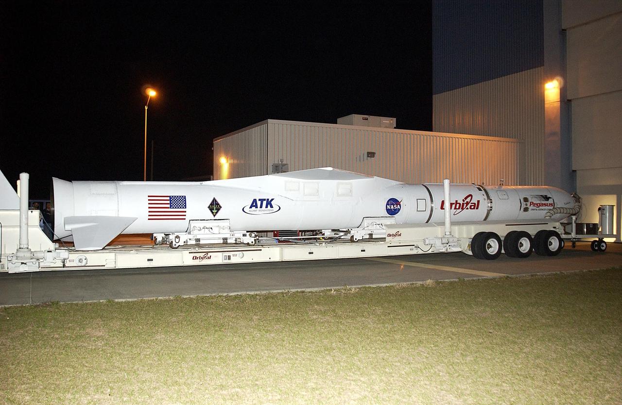 KENNEDY SPACE CENTER, FLA. - As darkness falls, the Pegasus launch vehicle arrives at the Multi-Payload Processing Facility (MPPF) at KSC. There it will be mated to the Galaxy Evolution Explorer (GALEX). The Pegasus will carry into orbit the GALEX, a space telescope that will observe galaxies in ultraviolet light across 10 billion years of cosmic history. Led by the California Institute of Technology, GALEX will conduct several first-of-a-kind sky surveys, including an extra-galactic (beyond our galaxy) ultraviolet all-sky survey. During its 29-month mission GALEX will produce the first comprehensive map of a Universe of galaxies under construction, bringing more understanding of how galaxies like the Milky Way were formed.  GALEX is due to be launched from Cape Canaveral Air Force Station March 25.