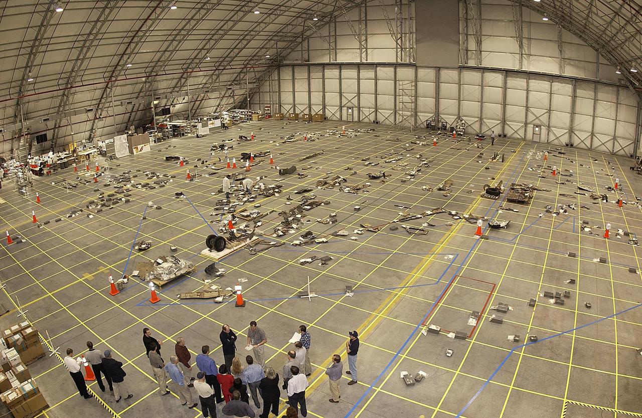 KENNEDY SPACE CENTER, FLA. -- In the RLV Hangar at KSC, pieces of debris from Columbia lie across the grid on the floor. Members of the Columbia Restoration Project Team are examining pieces and attempting to reconstruct the orbiter as part of the investigation into the accident that caused the destruction of Columbia on its return to Earth from mission STS-107. To date, four shipments have arrived from Barksdale AFB, Shreveport, La., the collection point for debris.