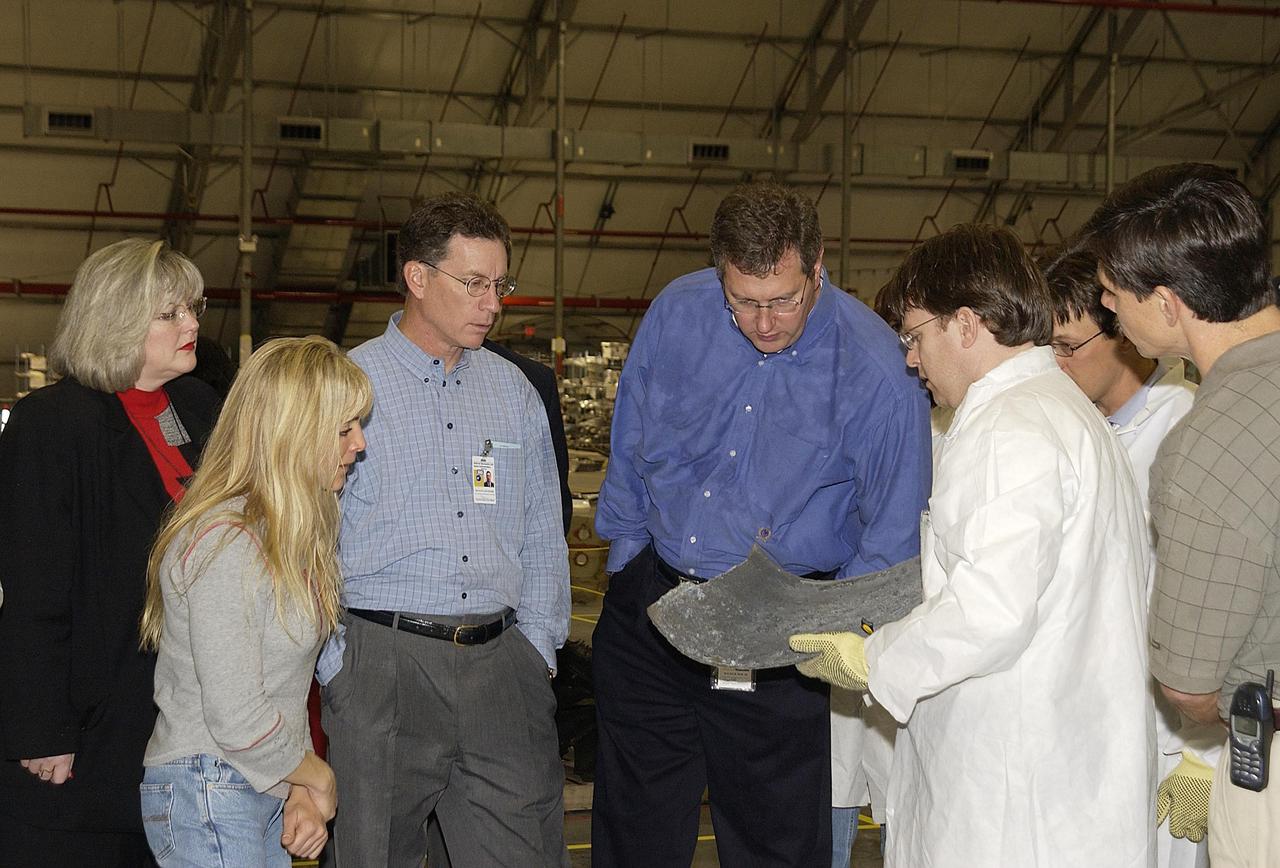 KENNEDY SPACE CENTER, FLA. -- Shuttle Program Manager Ron Dittemore (third from left) and Ralph Roe (fourth from left), with the Orbiter Work Group, JSC, examine a piece of debris from Columbia. A Columbia Restoration Project Team is examining pieces and attempting to reconstruct the orbiter as part of the investigation into the accident that caused the destruction of Columbia on its return to Earth from mission STS-107. To date, four shipments have arrived from Barksdale AFB, Shreveport, La., the collection point for debris.