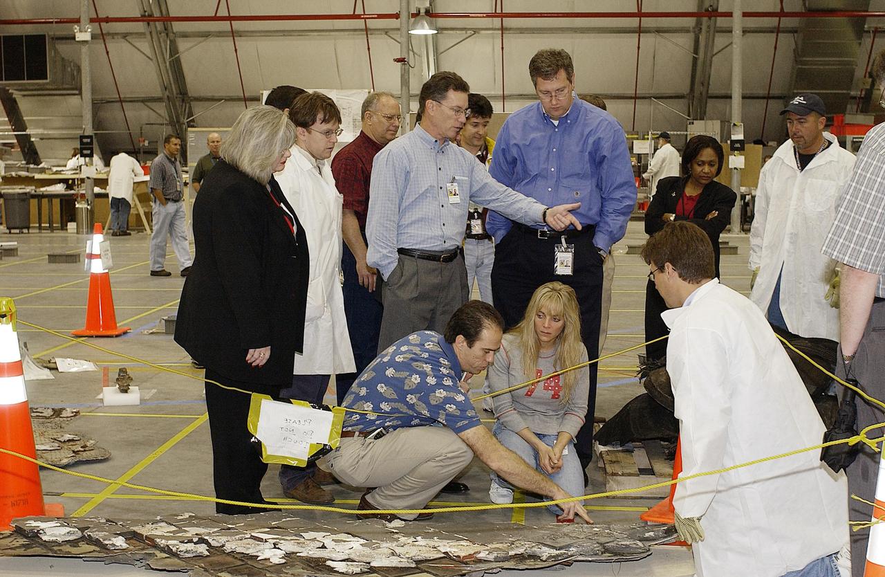 KENNEDY SPACE CENTER, FLA. - Shuttle Program Manager Ron Dittemore (center, pointing) looks over Columbia debris with members of the Columbia Restoration Project Team. To his right is Ralph Roe, with the Orbiter Work Group, JSC. The team is examining pieces and attempting to reconstruct the orbiter as part of the investigation into the accident that caused the destruction of Columbia on its return to Earth from mission STS-107. To date, four shipments have arrived from Barksdale AFB, Shreveport, La., the collection point for debris.