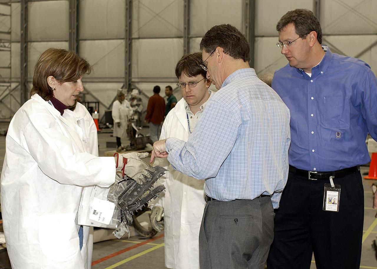 KENNEDY SPACE CENTER, FLA. - In the RLV Hangar at KSC, members of the Columbia Restoration Project Team show Shuttle Program Manager Ron Dittemore (third from left) and Ralph Roe, with the Orbiter Work Group at JSC, a piece of Columbia debris. The team is examining pieces and attempting to reconstruct the orbiter as part of the investigation into the accident that caused the destruction of Columbia on its return to Earth from mission STS-107. To date, four shipments have arrived from Barksdale AFB, Shreveport, La., the collection point for debris.