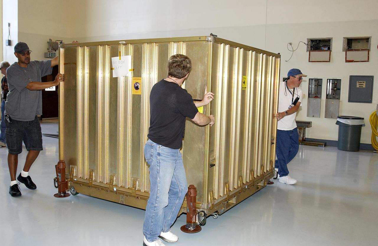 KENNEDY SPACE CENTER, FLA. -- The aeroshell for the Mars Exploration Rover-1 mission is moved into KSC's Multi-Payload Processing Facility.  While at KSC, the rovers, aeroshells and landers will undergo a full mission simulation. All of these flight elements will then be integrated together. After spin balance testing,  each spacecraft will be mated to a solid propellant upper stage booster that will propel the spacecraft out of Earth orbit. Approximately 10 days before launch they will be transported to the launch pad for mating with their respective Boeing Delta II rockets. The rovers will serve as robotic geologists to seek answers about the evolution of Mars, particularly  for a history of water. The rovers will be identical to each other, but will land at different regions of Mars.  Launch of the MER-1 is scheduled for May 30.  MER-2 will follow June 25.