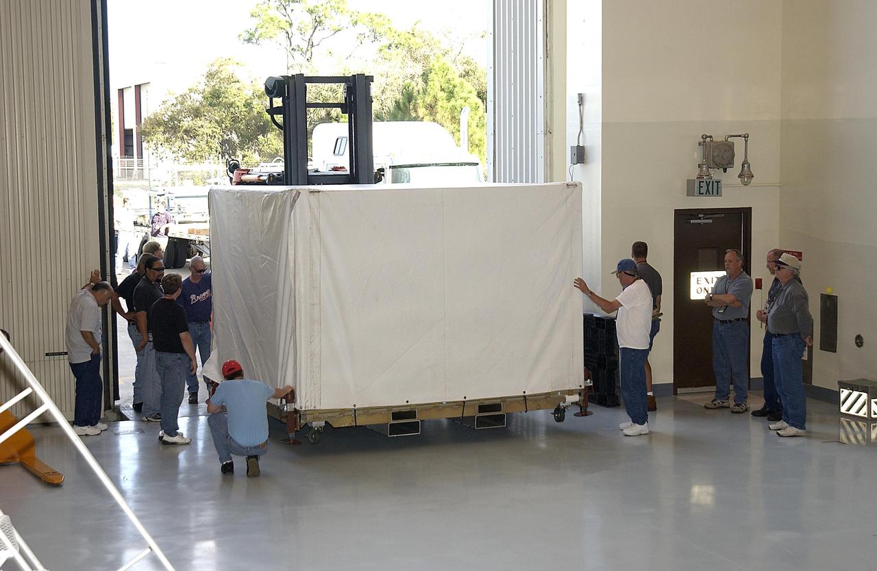 KENNEDY SPACE CENTER, FLA. -- Another component of the Mars Exploration Rover-1 mission is moved into KSC's Multi-Payload Processing Facility.  While at KSC, the rovers, aeroshells and landers will undergo a full mission simulation. All of these flight elements will then be integrated together. After spin balance testing,  each spacecraft will be mated to a solid propellant upper stage booster that will propel the spacecraft out of Earth orbit. Approximately 10 days before launch they will be transported to the launch pad for mating with their respective Boeing Delta II rockets. The rovers will serve as robotic geologists to seek answers about the evolution of Mars, particularly  for a history of water. The rovers will be identical to each other, but will land at different regions of Mars.  Launch of the MER-1 is scheduled for May 30.  MER-2 will follow June 25.