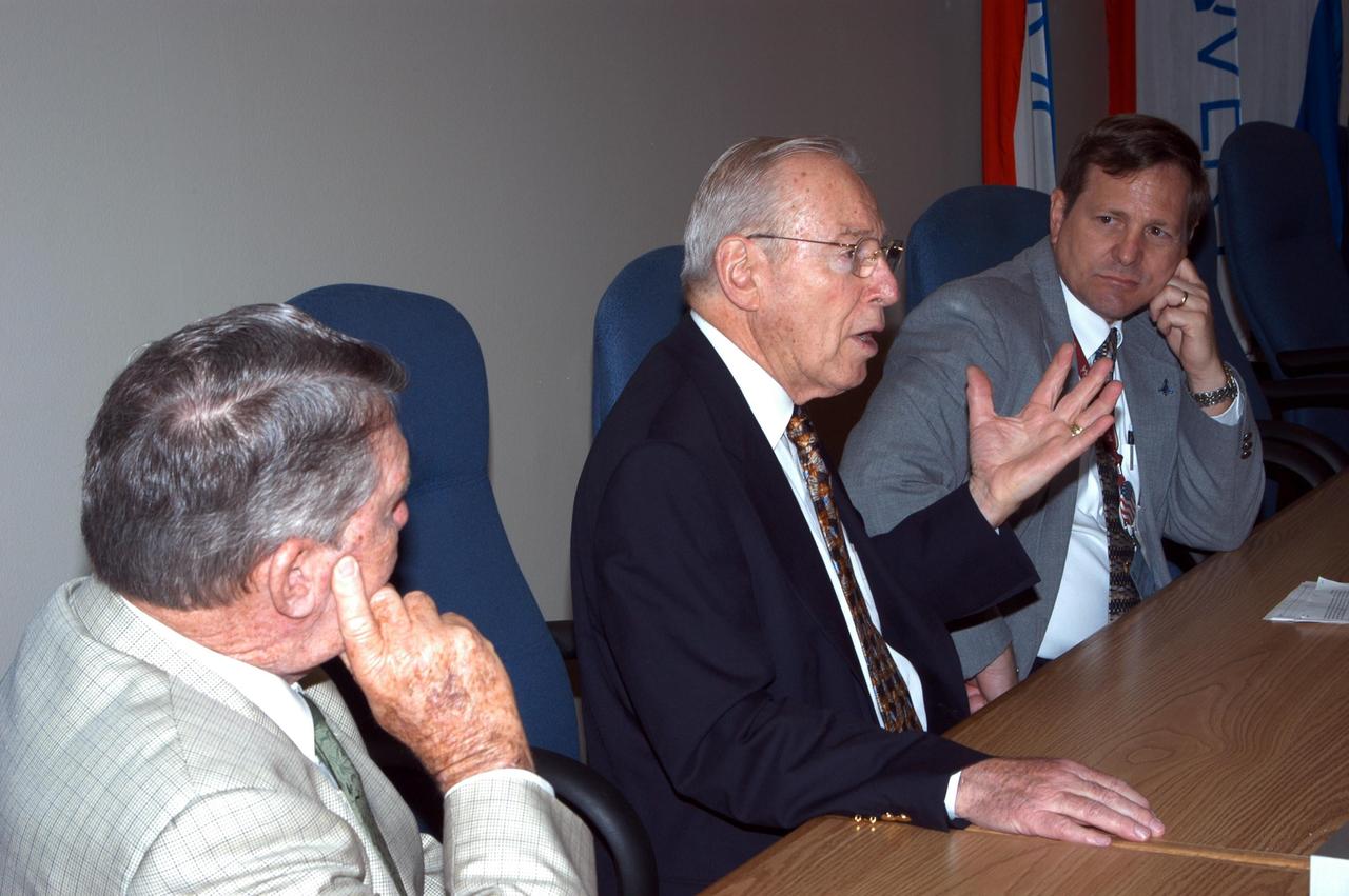 KENNEDY SPACE CENTER, FLA. - Former astronauts Jim Lovell (center) and Wally Schirra (left) talk with Mike Wetmore, director of Shuttle Processing (right) and others during a visit to KSC.  Lovell and Schirra visited KSC to talk about the space program and their experiences, as well as offer encouragement to workers to help get the space program "back on its feet."  They visited several sites around the Center, including the RLV Hangar where Columbia debris is being collected and examined as part of the investigation into the tragedy that claimed the orbiter and lives of seven astronauts returning from mission STS-107.