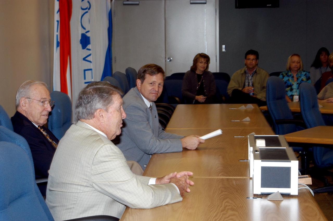KENNEDY SPACE CENTER, FLA. - From left, former astronauts Jim Lovell and Wally Schirra talk with Mike Wetmore, director of Shuttle Processing (right) and others during a visit to KSC.  Lovell and Schirra visited KSC to talk about the space program and their experiences, as well as offer encouragement to workers to help get the space program "back on its feet."  They visited several sites around the Center, including the RLV Hangar where Columbia debris is being collected and examined as part of the investigation into the tragedy that claimed the orbiter and lives of seven astronauts returning from mission STS-107.